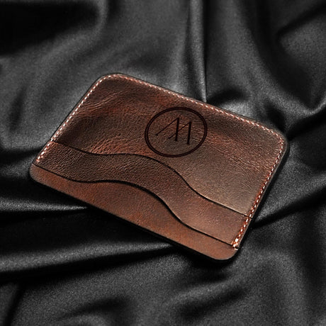 a leather business card holder on a black cloth