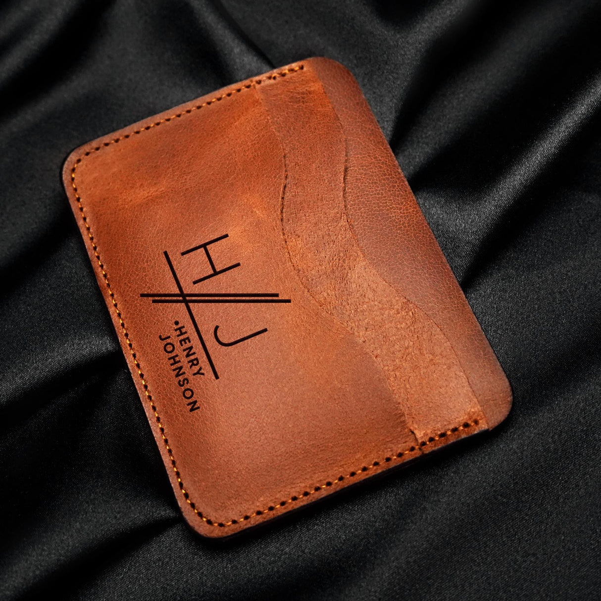 a leather wallet sitting on top of a black cloth