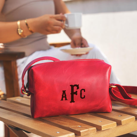 a red purse sitting on top of a wooden table