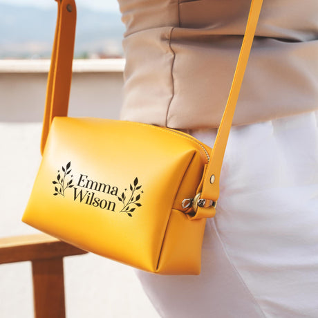 a woman holding a yellow purse with a name on it