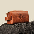 a brown leather bag sitting on top of a rock