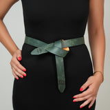 a woman in a black dress with a green belt