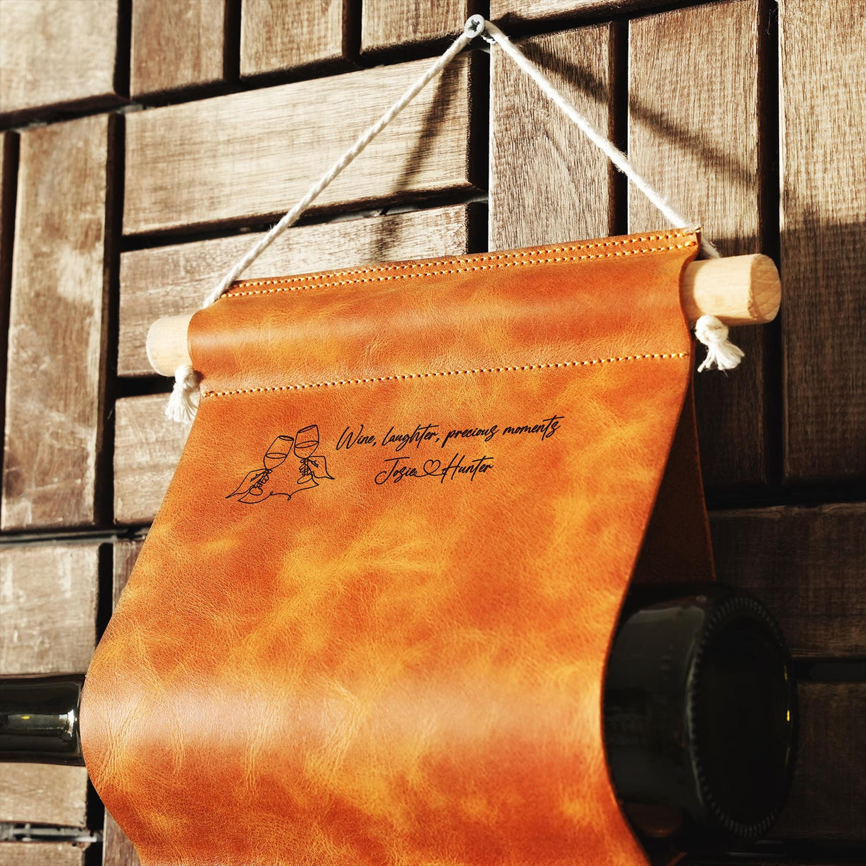 a leather wine bag hanging on a wooden wall