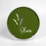 a green plate with a picture of a flower on it