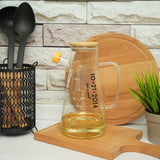 a wooden cutting board topped with a glass pitcher