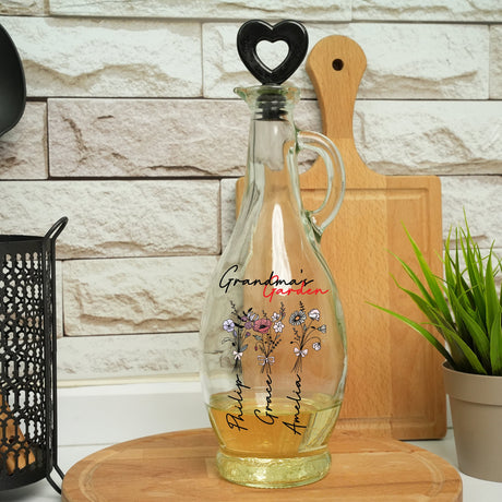 a glass bottle with flowers on it sitting on a cutting board