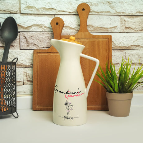 a white pitcher sitting on top of a counter next to a potted plant