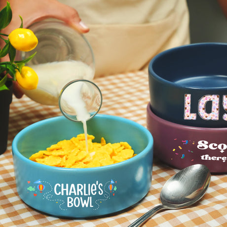 a person pouring milk into a bowl of cereal