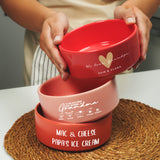 a person holding a red bowl on top of a table