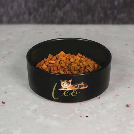 a black bowl filled with food on top of a counter