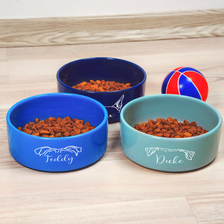 three bowls of dog food on a wooden table