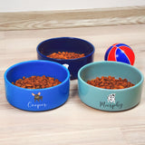 three bowls of dog food on a wooden table