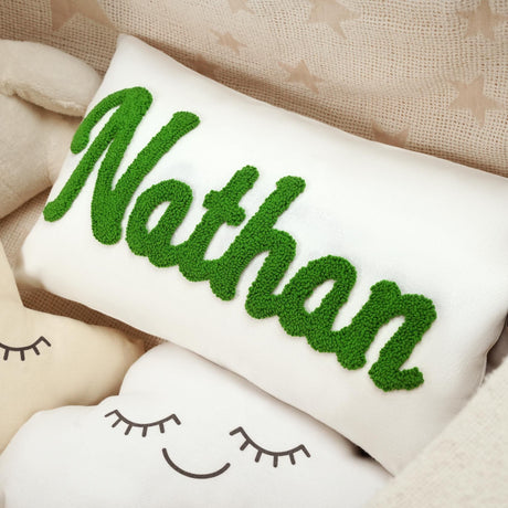 a white pillow with a green name on it