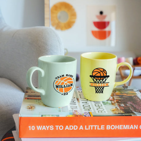 two coffee mugs sitting on top of a stack of books