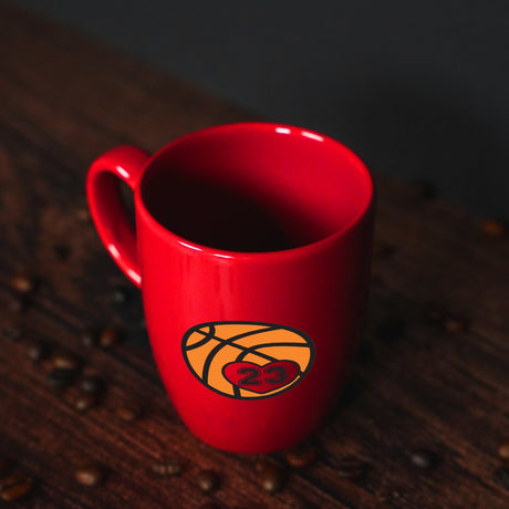 a red coffee mug with a basketball on it