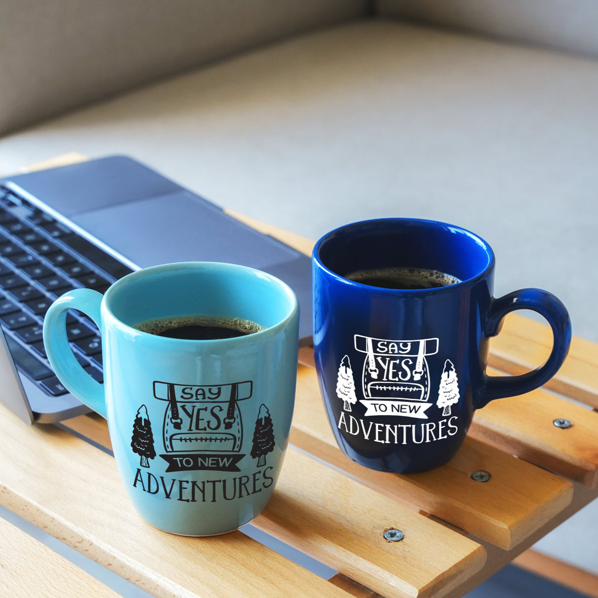 a cup of coffee and a laptop on a table