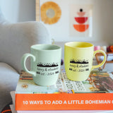 two coffee mugs sitting on top of a stack of books