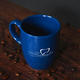 a blue coffee cup sitting on top of a wooden table