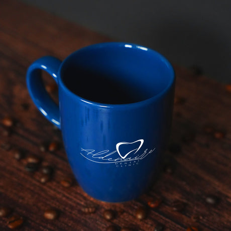 a blue coffee cup sitting on top of a wooden table