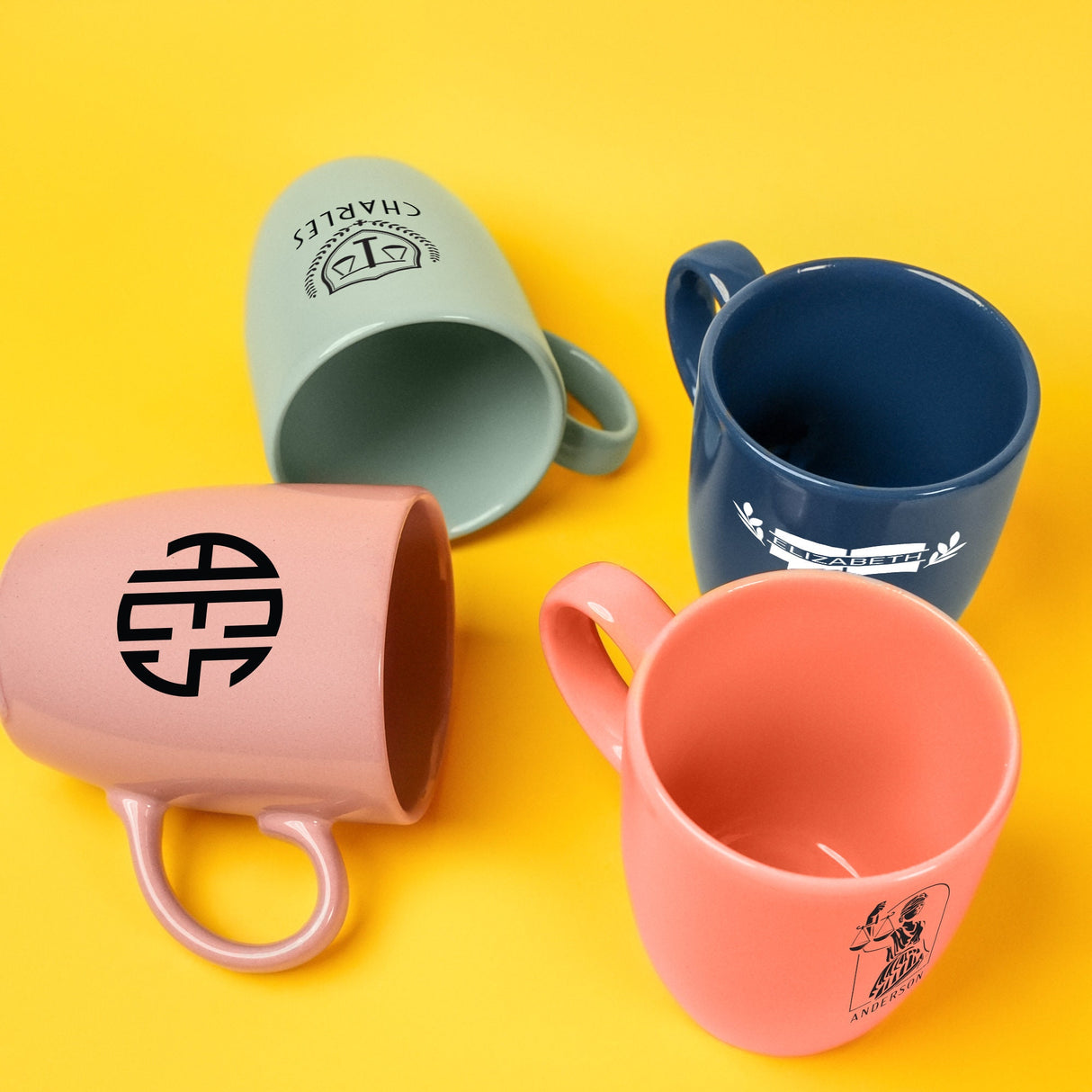 three coffee mugs sitting next to each other on a yellow surface