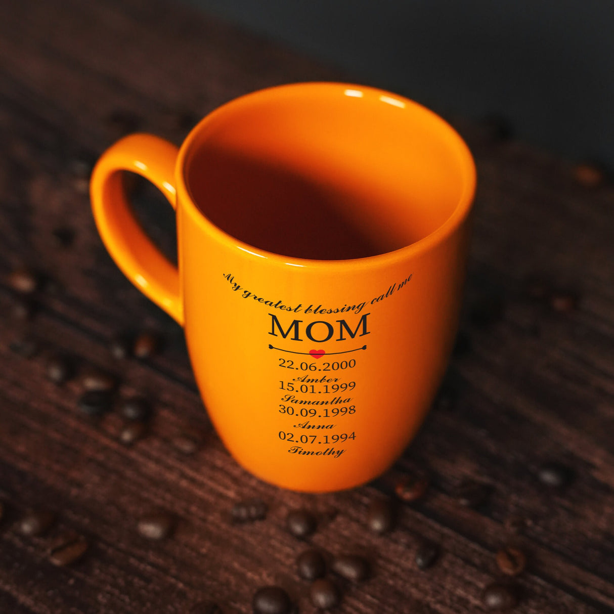 a yellow coffee mug with the name mom on it