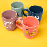 a group of four coffee mugs sitting on top of a yellow table