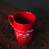 a red coffee mug sitting on top of a wooden table