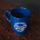 a blue coffee mug sitting on top of a wooden table