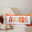 a pillow with the word aurora on it next to a cup of coffee