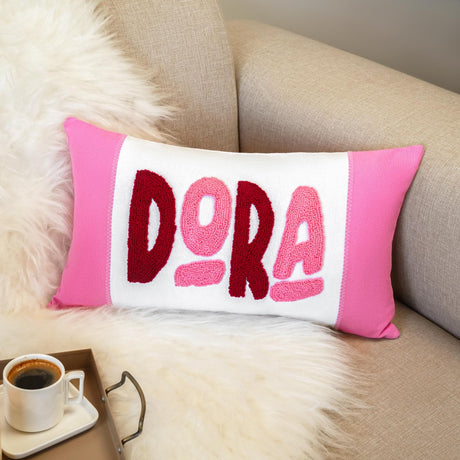 a pink and white pillow sitting on top of a couch