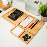 a desk with a cell phone, calculator, pen, and pencil