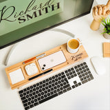 a desk with a keyboard, mouse, cell phone and a mouse pad