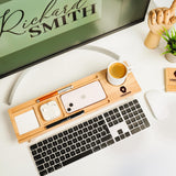 a desk with a keyboard, mouse, cell phone and a cup of coffee