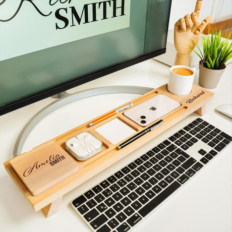 a desk with a keyboard, mouse and cell phone