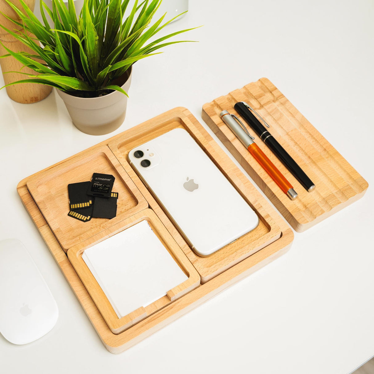 a desk with a cell phone, pen and mouse