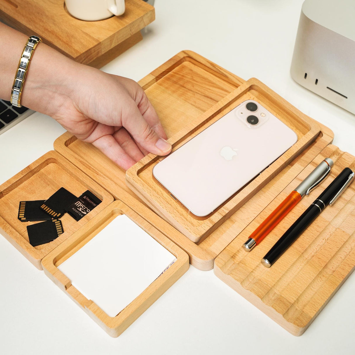 a person holding a cell phone in a wooden tray