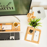 a desk with a keyboard, mouse, cell phone and a plant