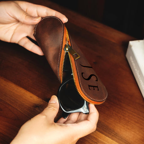 a person holding a pair of glasses in a case