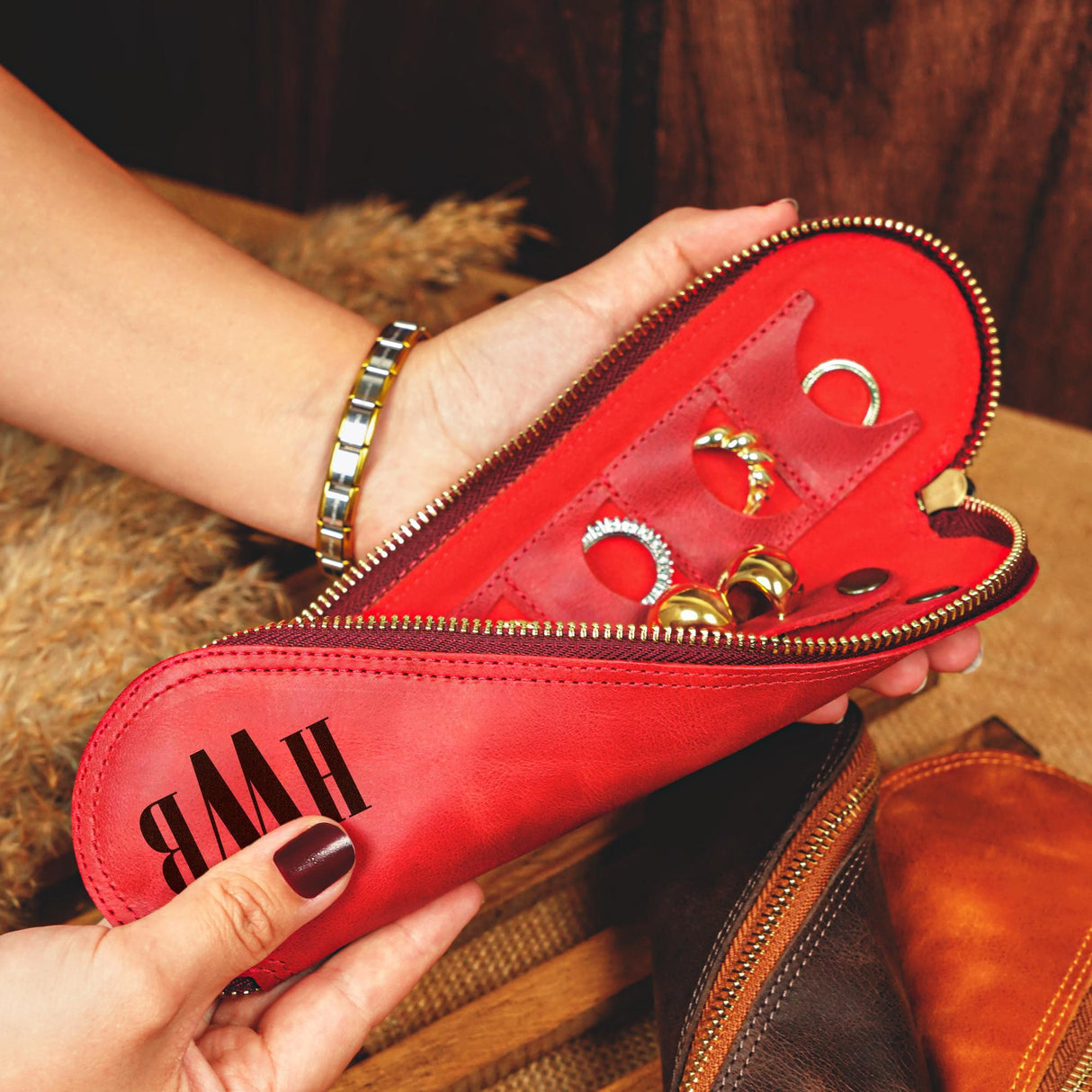 a woman is holding a red case with rings on it