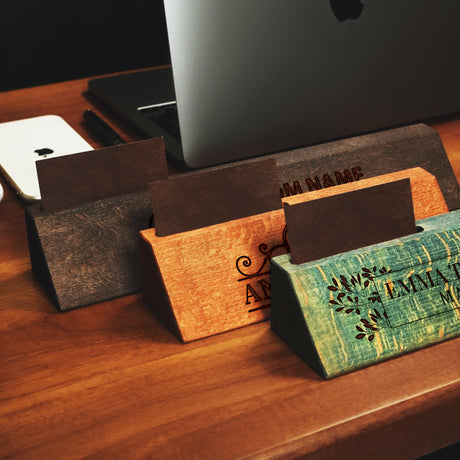 a wooden desk with a laptop and several business cards