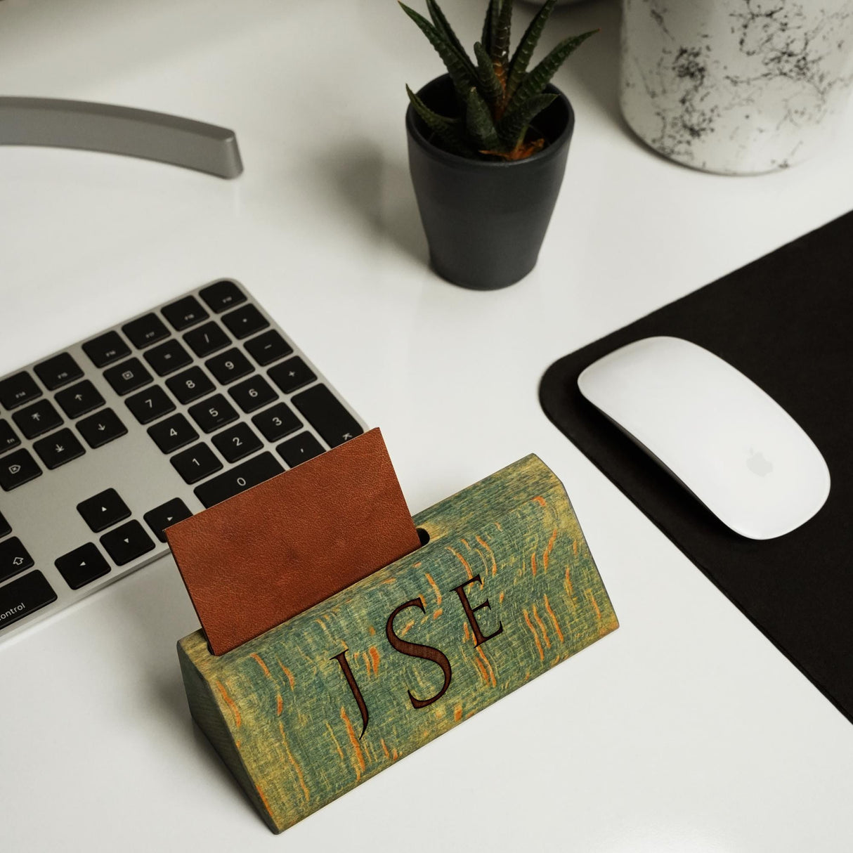 a desk with a keyboard, mouse and a wooden block