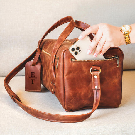 a person holding a cell phone in a brown bag