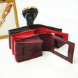 a red wallet sitting on top of a table next to a mirror