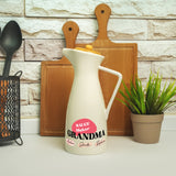 a white pitcher sitting on top of a counter next to a potted plant