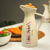 a white pitcher sitting on top of a table next to a bowl of salad