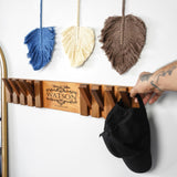 a person is holding a hat and a hat rack