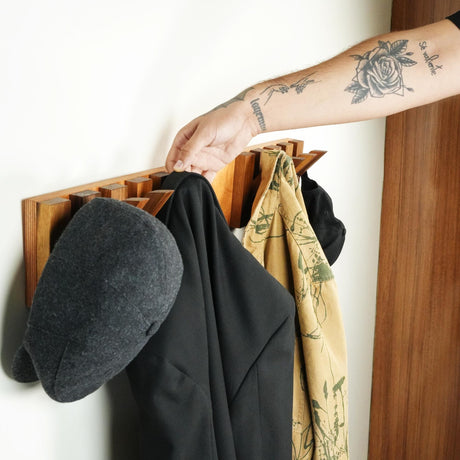 a person&#39;s arm hanging on a coat rack