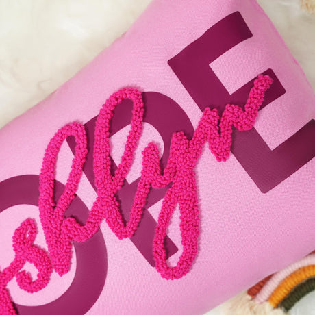 a pink pillow with the word love spelled out