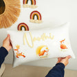 a person holding a pillow with a name on it