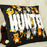 a black pillow with a bunch of animals on it